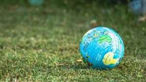 A globe-themed beach ball sits on grass.