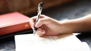 Someone writes in a journal.