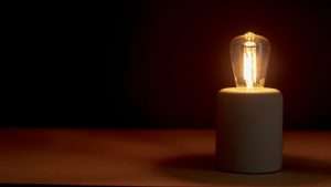 A lightbulb dimly lights a dark space.