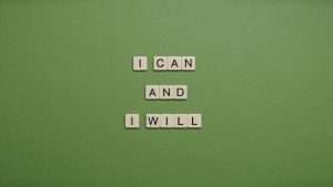 Letter tiles on a green backdrop spell out the sentence "I can and I will."