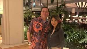 Howie & Theresa Danzik™ standing next to each other in front of massive plants.